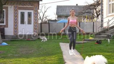 家里有<strong>跳绳</strong>的健康年轻女子的画像。女健身者在阳光明媚的日子在户外做<strong>跳绳</strong>运动。